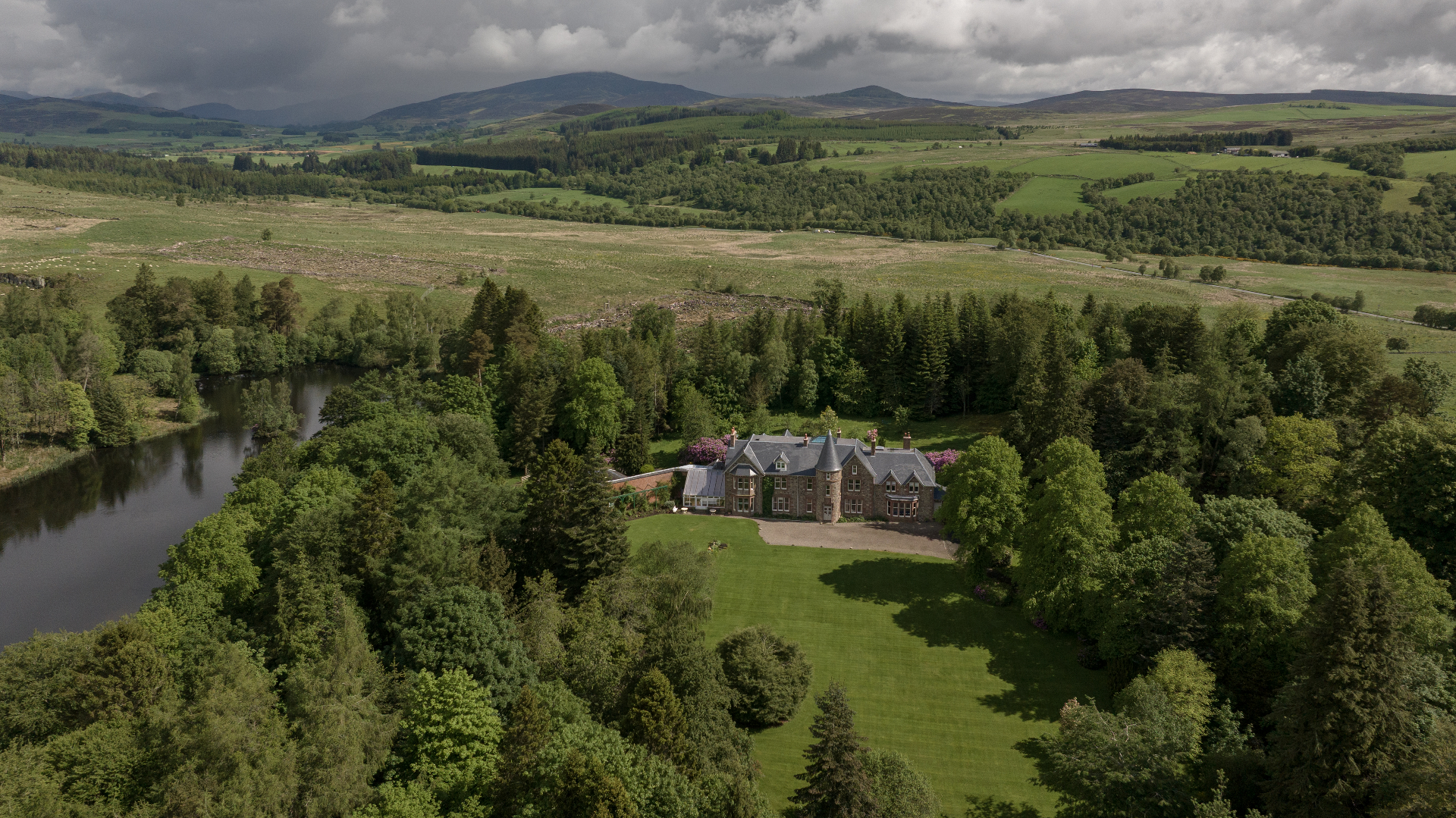Aerial view of the Highland estate set among woodland, gardens and a quiet loch